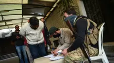 epa11788119 An opposition rebel fighter (C) registers a former soldier as the former soldiers of the Bashar al-Assad regime present the identification papers and weapons to Hayat Tahrir al-Sham (HTS) forces to settle their status, in Damascus, Syria, 21 December 2024, after opposition forces led by HTS toppled President al-Assad. EPA/HASAN BELAL