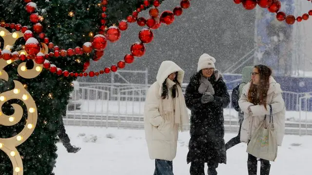 epa11786909 People walk during a snowstorm in Bishkek, Kyrgyzstan, 20 December 2024. Temperatures in Bishkek dropped sharply to -5 to -7 degrees Celsius. EPA/IGOR KOVALENKO