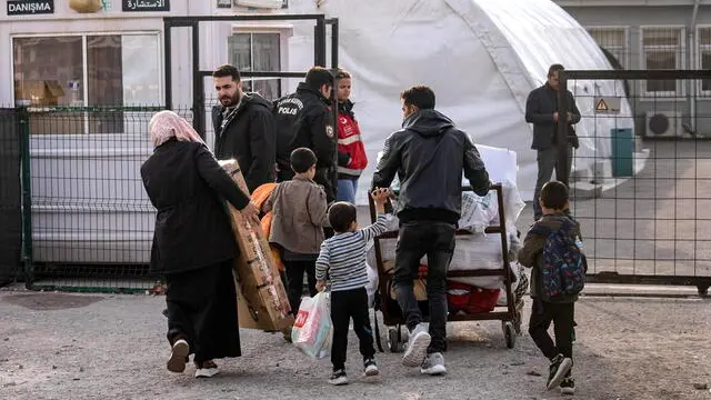 epa11772617 Syrians carry their luggage as they wait to cross into Syria from Turkey at the Oncupinar border gate, near the town of Kilis, southern Turkey, 12 December 2024. The Political Affairs Department of the Syrian Salvation government called for all refugees outside Syria to return following the ousting of Syrian President Bashar al-Assad on 08 December, as the UN Refugee Agency (UNHCR) estimates that since 2011, more than 14 million Syrians were forced to flee their homes in search of safety. EPA/KAZIM KIZIL