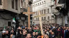 epa11791847 Protesters hold crosses and shout slogans during a demonstration in the Bab Touma neighborhood of Damascus, Syria, 24 December 2024. Syrian Christians demonstrated against the burning of a Christmas tree overnight by masked men in the town of Suqaylabiyah in the Hama governorate.Â EPA/HASAN BELAL