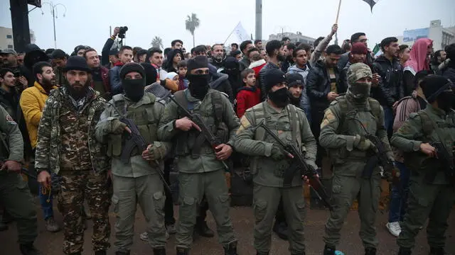 epa11790366 Armed rebel fighters keep watch as people take part in a 'Liberation Festival' to celebrate the ouster of Syrian president Bashar Al-Assad, in Idlib, northwestern Syria, 22 December 2024. Idlib has been a stronghold for Hay'at Tahrir al-Sham (HTS), the rebel group that along with other Syrian opposition groups toppled the Assad regime on 08 December 2024. EPA/BILAL AL HAMMOUD