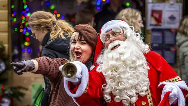 epaselect epa11788837 A visitor gestures next to a Santa Claus at the Magical Maastricht Christmas market on the Vrijthof, in Maastricht, the Netherlands, 21 December 2024. The traditional market houses numerous stalls, attractions and catering establishments. EPA/MARCEL VAN HOORN