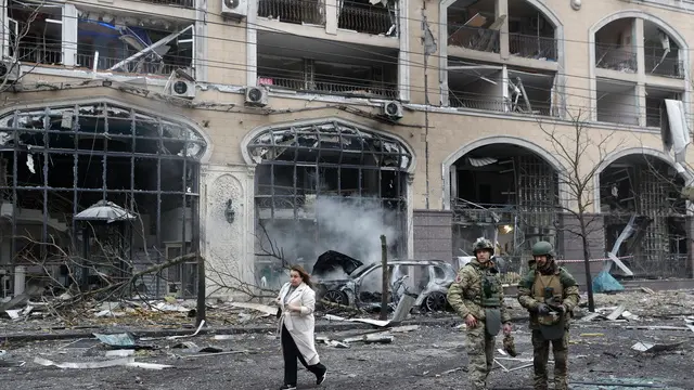 epa11786780 A Ukrainian woman walks past two officers near a damaged building at the site of a missile strike in downtown Kyiv, Ukraine, 20 December 2024, amid the Russian invasion. At least one person was killed and 10 others injured as a result of Russian shelling in Kyiv, according to the State Emergency Service of Ukraine (SESU). EPA/SERGEY DOLZHENKO