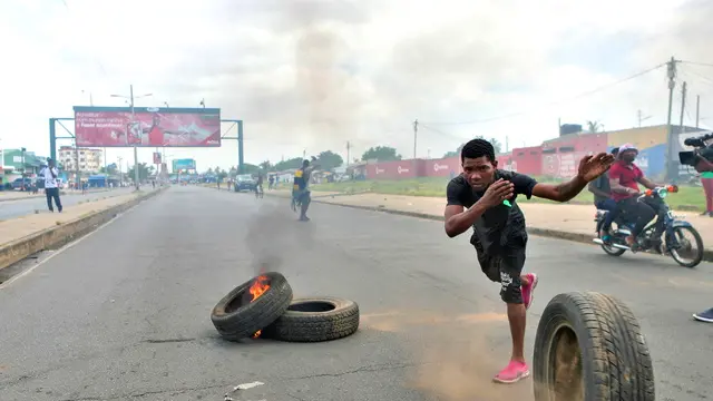 epa11760092 A man throws a burning tire from a barricade during a post-election protest in a street of Maputo, Mozambique, 06 December 2024. In recent weeks, supporters of former presidential candidate Venancio Mondlane, who is currently in exile, have taken to the streets of the Mozambican capital to challenge the results of the disputed general election held in October 2024. EPA/LUISA NHANTUMBO