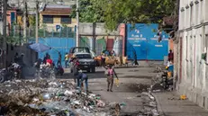 epa11767343 People walk amidst garbage on a street near the National Palace, in Port-au-Prince, Haiti, 09 December 2024. The Government of Haiti raised the death toll to around 180 people in the massacre perpetrated by an armed gang in Warf Jeremie, in the Cite Soleil area of the Port-au-Prince metropolitan area, and warned that "a red line" has been crossed with this massacre. EPA/MENTOR DAVID LORENS