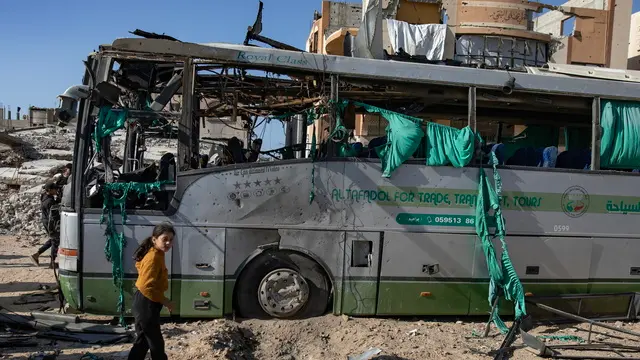 epa11791012 Palestinians inspect a bus hit by an Israeli airstrike in Khan Yunis, southern Gaza Strip, 23 December 2024. At least two people were injured in an Israeli airstrike on a bus in Khan Yunis, according to medics at Nasser Hospital. More than 45,000 Palestinians and over 1,400 Israelis have been killed, according to the Palestinian Health Ministry and the Israeli Army, since Hamas militants launched an attack against Israel from the Gaza Strip on 07 October 2023, and the Israeli operations in Gaza and the West Bank which followed it. EPA/HAITHAM IMAD