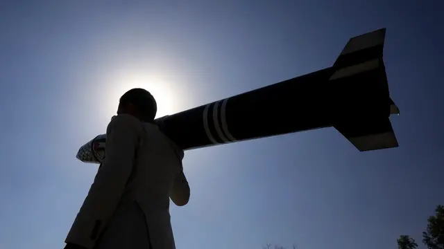 epa11793200 A person carries a mock missile during a rally in solidarity with the Palestinian people, in Sana'a, Yemen, 25 December 2024. Yemen's Houthis have claim responsibility for a hypersonic ballistic missile attack on the Israeli city of Tel Aviv in support for the Palestinian people amid the Israeli military operations in the Gaza Strip, Houthi military spokesman Yahya Sarea said in a statement. EPA/YAHYA ARHAB