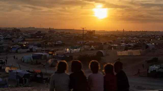 epa11790129 A group of displaced Palestinian children, who fled their homes due to Israeli airstrikes and evacuation orders, sits near their tents in a makeshift camp at sunset in Khan Younis camp, southern Gaza Strip, 22 December 2024. According to the UN, at least 1.9 million people (or nine in ten people) across the Gaza Strip are internally displaced, including people who have been repeatedly displaced. Since October 2023, only about 11 percent of the Gaza Strip has not been placed under Israeli-issued evacuation orders, the UN aid coordination office OCHA said. EPA/HAITHAM IMAD