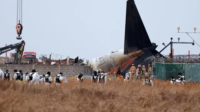 epa11796953 KCSI (Korea Criminal Investigation) members search around the wreckage of the Jeju Air aircraft at Muan International Airport in Muan, 288 kilometers southwest of Seoul, South Korea, 29 December 2024. According to the National Fire Agency, a passenger jet carrying 181 people erupted in flames after going off the runway at an airport in South Korea's southwestern county of Muan on 29 December, leaving at least 62 people dead. EPA/HAN MYUNG-GU