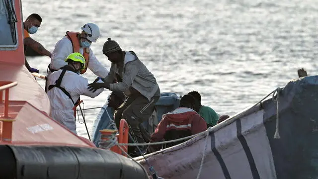 epa11794130 Members of the Spanish 'Salvamento Maritimo' safe and rescue brigade help migrants upon their arrival at La Restinga port in El Hierro, Canary Islands, Spain, 26 December 2024. Three small dugout boats carrying 196 people have arrived in the Canary Islands in the last few hours. EPA/GELMERT FINOL