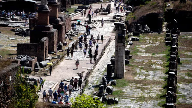Turisti visitano il Parco archeologico del Colosseo e Fori Imperiali, Roma, 16 agosto 2023. ANSA/ANGELO CARCONI