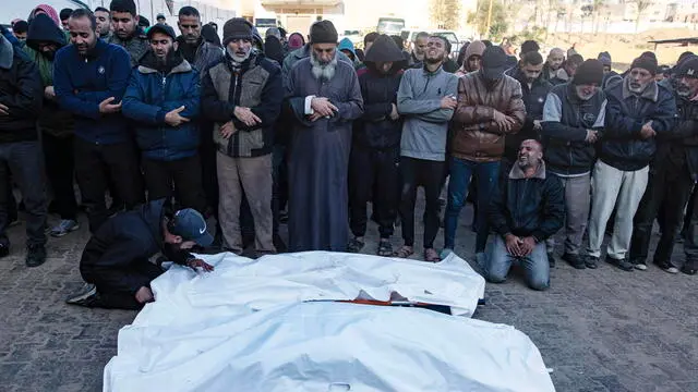 epa11801979 Palestinians pray next to the bodies of their relatives killed during an Israeli airstrike on an internally displaced persons camp in Al-Mawasi area, west of Khan Yunis, southern Gaza Strip, 02 January 2025. Ten Palestinians were killed in the airstrike, according to the local Nasser Hospital. According to the UN, at least 1.9 million people (or nine in ten people) across the Gaza Strip are internally displaced, including people who have been repeatedly displaced. Since October 2023, only about 11 percent of the Gaza Strip has not been placed under Israeli-issued evacuation orders, the UN aid coordination office OCHA said. EPA/HAITHAM IMAD