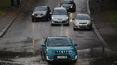 epa11620246 Cars attempt to navigate a flooded road in London, Britain, 23 September 2024. Environment Agency issued a flood warning for parts of England as heavy rain is expected. EPA/NEIL HALL