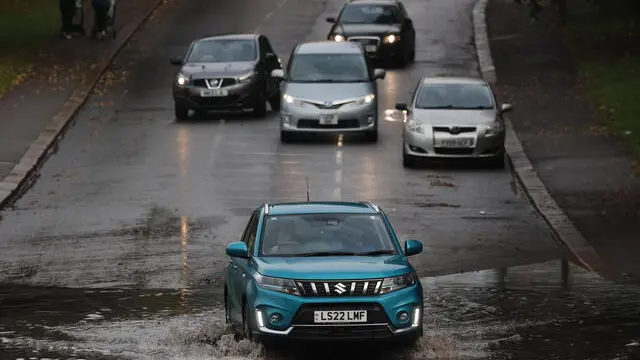 epa11620246 Cars attempt to navigate a flooded road in London, Britain, 23 September 2024. Environment Agency issued a flood warning for parts of England as heavy rain is expected. EPA/NEIL HALL