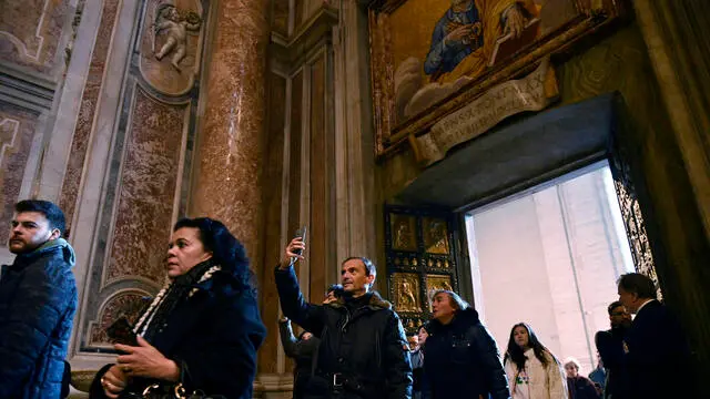 Pilgrims pass the Holy Door of St Peter's Basilica in the Vatican after the start of the Catholic Jubilee Year, 25 December 2024