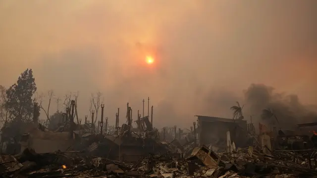 epaselect epa11813904 The sun shines through smoke above ruins of homes from the Palisades wildfire in the Pacific Palisades neighborhood of Los Angeles, California, USA, 08 January 2025. According to data from California Department of Forestry and Fire Protection (CAL FIRE), multiple wildfires are burning across thousands of acres and forced tens of thousands of evacuations in the Los Angeles area. EPA/ALLISON DINNER