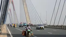 epa11674112 A man rides a motorbike across a bridge in Hanoi, Vietnam, 22 October 2024. Vietnamese Prime Minister Pham Minh Chinh aims for an economic growth of 7 to 7.5 percent in 2025, according to his address during the 8th session of the National Assembly's 15th tenure in Hanoi on 21 October. EPA/LUONG THAI LINH