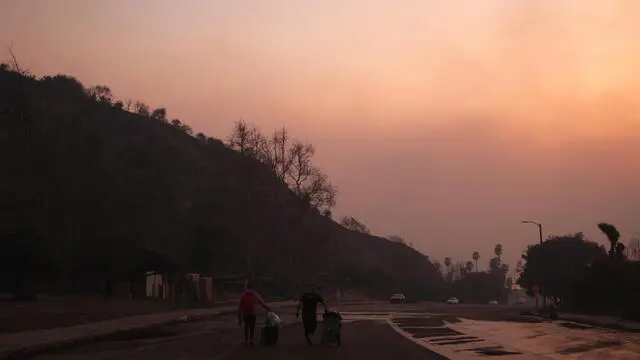 epa11814098 People evacuate with luggage from the Palisades wildfire in the Pacific Palisades neighborhood of Los Angeles, California, USA, 08 January 2025. According to data from California Department of Forestry and Fire Protection (CAL FIRE) multiple wildfires are burning across thousands of acres and forcing thousands of evacuations and destroying hundreds of homes in the Los Angeles area. EPA/ALLISON DINNER