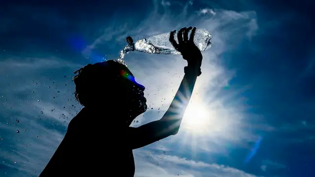 epaselect epa11545826 A boy pours water over himself during high heat in Brussels, Belgium, 11 August 2024. After months of rain in Belgium, the country is bracing for its first summer heat wave. This year has been the rainiest on record. EPA/FREDERIC SIERAKOWSKI