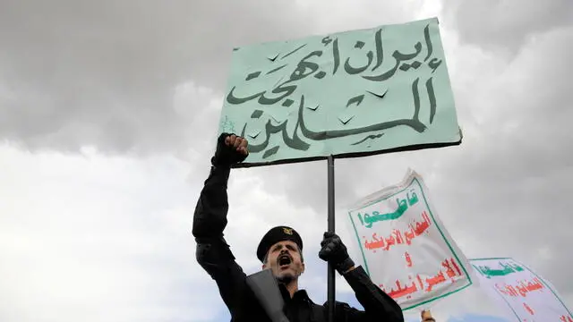 epa11288849 A Houthi supporter (L) holds a placard reading in Arabic 'Iran delighted Muslims' as others holds placards reading in Arabic 'Boycott US and Israeli goods' during a protest against the US and Israel, and in solidarity with the Palestinians, in Sana'a, Yemen, 19 April 2024. Thousands of Houthi supporters participated in a protest against the United States and Israel and to show their solidarity with the Palestinians of Gaza amid the ongoing conflict between Israel and Hamas. The protest came just a day after the Houthis' top leader, Abdul-Malik al-Houthi, claimed his group had launched some 14 drone and missile attacks against shipping lanes in the Red Sea and the Gulf of Aden and towards the southern Israeli port of Eilat in the last two weeks in support of the Palestinian people in the Gaza Strip. EPA/HAMZA ALI