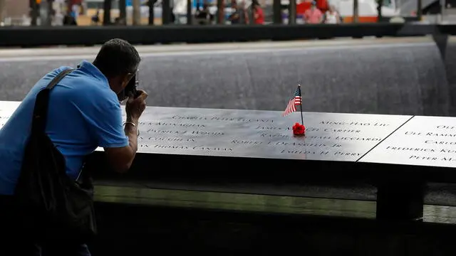 epa09456086 A man takes picture at the south memorial pool a few days before the 20th anniversary of the September 11 terror attack in New York, New York, USA, 08 September 2021. On 11 September 2001, during a series of coordinated terror attacks using hijacked airplanes, two airplanes were flown into the World Trade Center's twin towers causing the collapse of both towers. A third plane targeted the Pentagon and a fourth plane heading towards Washington, DC ultimately crashed into a field. The 20th anniversary of the worst terrorist attack on US soil will be observed on 11 September 2021. EPA/Peter Foley