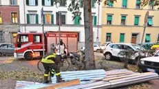 Vigili del fuoco intervengono per una lamiera cascata da un tetto per il forte vento, Firenze, 26 novembre 2015. ANSA/MAURIZIO DEGL INNOCENTI