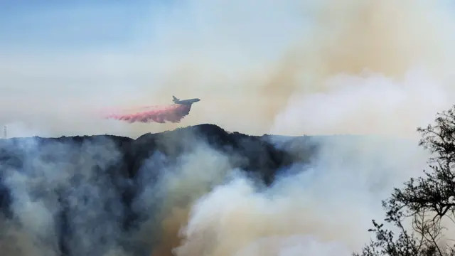 epaselect epa11817428 A plane drops fire retardant on a section of the Palisades wildfire in the Pacific Palisades area of Los Angeles, California, USA, 10 January 2025. Thousands of firefighting and emergency personnel are involved in response efforts, as multiple wildfires are continuing to burn across thousands of acres in Southern California, destroying thousands of homes and forcing people to evacuate areas throughout the Los Angeles area. EPA/ALLISON DINNER
