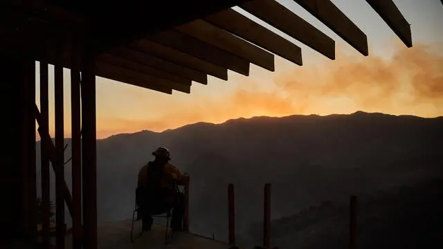 epa11819253 A firefighter keeps watch over a burned canyon during the Palisades wildfire in Los Angeles, California, USA, 11 January 2025. Thousands of firefighting and emergency personnel are involved in response efforts, as multiple wildfires are continuing to burn across thousands of acres in Southern California, destroying thousands of homes and forcing people to evacuate areas throughout the Los Angeles area. EPA/ALLISON DINNER