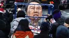 epa11787919 Participants display a chained effigy depicting impeached South Korean President Yoon Suk Yeol during a rally by civic groups calling for Yoon's resignation in Seoul, South Korea, 21 December 2024. South Korean President Yoon Suk Yeol is currently suspended from his presidential powers, after the National Assembly passed an impeachment motion against him on 14 December, in response to Yoon's short-lived martial law decree on 03 December 2024. EPA/JEON HEON-KYUN