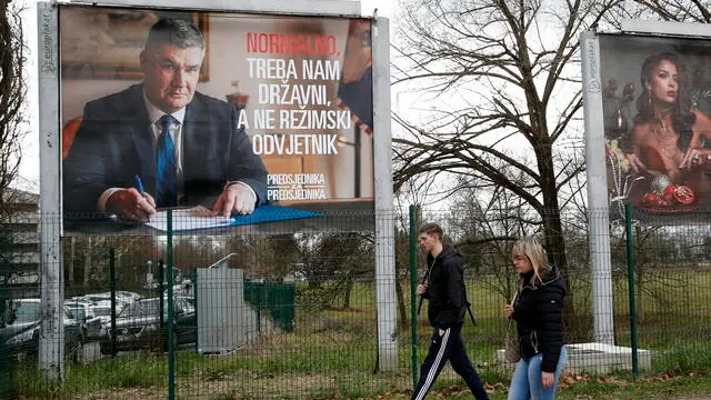 epa11814550 People pass in front of an election poster of presidential candidate and incumbent President of Croatia, Zoran Milanovic, in Zagreb, Croatia, 09 January 2025. Croatia will hold the second round of presidential elections on 12 January 2025. EPA/ANTONIO BAT