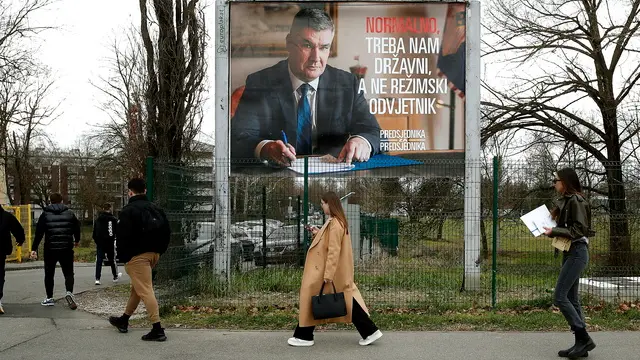 epaselect epa11814547 People pass in front of an election poster of presidential candidate and incumbent President of Croatia, Zoran Milanovic, in Zagreb, Croatia, 09 January 2025. Croatia will hold the second round of presidential elections on 12 January 2025. EPA/ANTONIO BAT