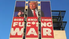 Un cartellone apparso il 13 gennaio a Gerusalemme in cui Trump esorta Nethanyahu a porre fine al conflitto - Foto Ansa/Epa © www.giornaledibrescia.it