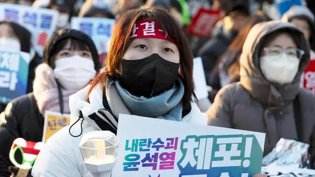 epa11817984 Members of Civic groups hold baners reading 'Immediate arrest' during a rally in Seoul, South Korea, 11 January 2025. On 07 January 2025, a court refiled a warrant to extend the deadline to detain Yoon over his failed bid to impose martial law in December 2024. EPA/JEON HEON-KYUN