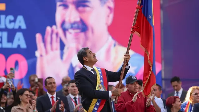 epa11817532 Venezuelan President Nicolas Maduro holds a flag during an event in Caracas, Venezuela, 10 January 2025. Maduro defended his presidential investiture for a third six-year term, questioned by anti-Chavismo and much of the international community following opposition allegations of â€œfraudâ€ during last years July presidentail elections, as a â€œgreat Venezuelan victoryâ€ and celebrated that it could not be â€œpreventedâ€. EPA/RONALD PENA R.