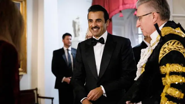 epa11757144 Lord Mayor of London Alastair King (R) welcomes the Emir of Qatar Sheikh Tamim bin Hamad Al Thani (C) to Mansion House for a dinner event in London, Britain, 04 December 2024. The emir of Qatar and his wife are on a state visit to Britain from 03 to 04 December 2024. EPA/TOLGA AKMEN