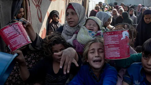 epa11816525 Palestinians, including children, hold metal pots and pans as they gather to receive food cooked by a charity kitchen, in Khan Yunis, southern Gaza Strip, 10 January 2025. According to the UN Palestinian refugee agency UNRWA, over 1.8 million people across the Gaza Strip are experiencing 'high levels' of acute food insecurity, with acute malnutrition ten times higher than before the war. According to the UN, at least 1.9 million people, about 90 percent of the population, across the Gaza Strip are internally displaced, including people who have been repeatedly displaced. EPA/HAITHAM IMAD