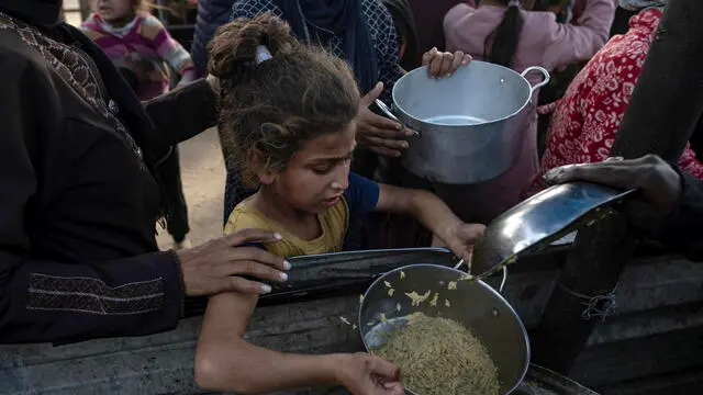 epa11816520 Palestinians, including children, hold metal pots and pans as they gather to receive food cooked by a charity kitchen, in Khan Yunis, southern Gaza Strip, 10 January 2025. According to the UN Palestinian refugee agency UNRWA, over 1.8 million people across the Gaza Strip are experiencing 'high levels' of acute food insecurity, with acute malnutrition ten times higher than before the war. According to the UN, at least 1.9 million people, about 90 percent of the population, across the Gaza Strip are internally displaced, including people who have been repeatedly displaced. EPA/HAITHAM IMAD