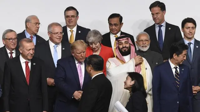 epa07679075 US President Donald J. Trump (C) greets Chinese President Xi Jinping as other world leaders look on during the Leaders family photograph at the G20 leaders summit in Osaka, Japan, 28 June 2019. The leaders of the world's largest economies gathered in Osaka for the fourteenth meeting of Group of Twenty (G20). EPA/LUKAS COCH AUSTRALIA AND NEW ZEALAND OUT