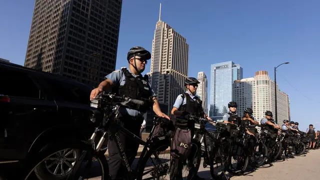 epa11554695 Police stand on duty downtown near a demonstration ahead of the Democratic National Convention (DNC) in Chicago, Illinois, USA, 18 August 2024. The Democratic National Convention is due to run from 19 August until 22 August 2024. EPA/MICHAEL REYNOLDS