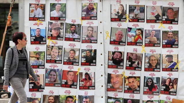 epa11830530 A woman walks past a display of posters calling for the release of Israeli hostages, who were abducted by militants during the 07 October 2023 Hamas attacks, outside the Kirya military headquarters in Tel Aviv, Israel, 17 January 2025. Israel and Hamas have agreed on a hostage release deal and a Gaza ceasefire to be implemented in the coming days following months of war. Israel's security cabinet is expected to meet on 17 January to approve the agreement. EPA/ABIR SULTAN