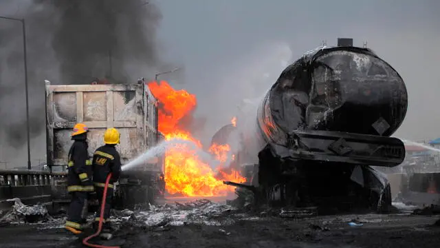 epa08500844 Firefighters spray water to extinguish a fire at the site of an accident after multiple fuel tankers spilled their cargo on a bridge along Lagos-Ibadan expressway in Lagos, Nigeria, 21 June 2020. Two people were reported dead in the overnight fire involving multiple fuel tankers. Oil tanker accident is a common phenomenon in a city of about 21 million people. EPA/AKINTUNDE AKINLEYE