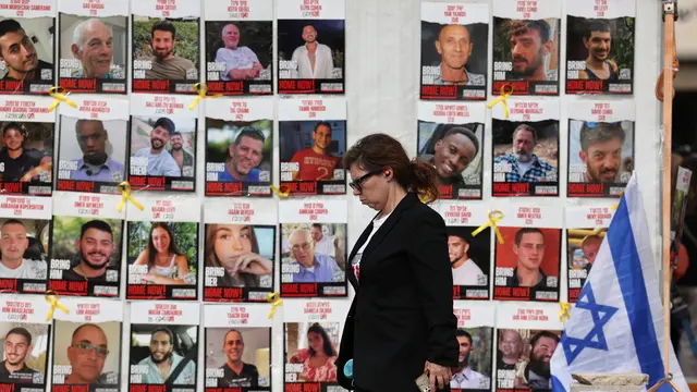 epaselect epa11830531 A woman walks past a display of posters calling for the release of Israeli hostages, who were abducted by militants during the 07 October 2023 Hamas attacks, outside the Kirya military headquarters in Tel Aviv, Israel, 17 January 2025. Israel and Hamas have agreed on a hostage release deal and a Gaza ceasefire to be implemented in the coming days following months of war. Israel's security cabinet is expected to meet on 17 January to approve the agreement. EPA/ABIR SULTAN