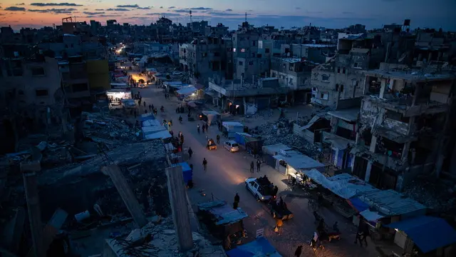 epa11834347 Palestinians walk through a market in Khan Younis, southern Gaza Strip, 18 January 2025. A ceasefire between Israel and Hamas will take effect on 19 January 2025. More than 46.000 people have been killed in Gaza since October 2023, when Israel launched a military campaign in response to a cross-border attack by Hamas, in which about 1,200 people were killed and over 200 taken hostage. EPA/HAITHAM IMAD