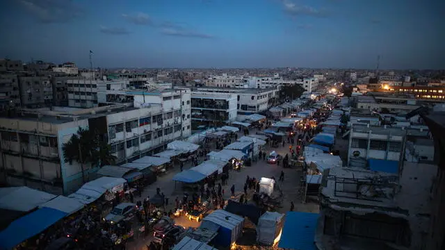 epa11834345 Palestinians walk through a market in Khan Younis, southern Gaza Strip, 18 January 2025. A ceasefire between Israel and Hamas will take effect on 19 January 2025. More than 46.000 people have been killed in Gaza since October 2023, when Israel launched a military campaign in response to a cross-border attack by Hamas, in which about 1,200 people were killed and over 200 taken hostage. EPA/HAITHAM IMAD