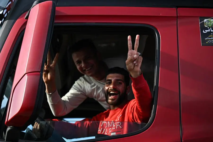 epa11836839 A driver cheers as trucks of humanitarian aid bound for the Gaza Strip cross at the Rafah border crossing between the Gaza Strip and Egypt, in Rafah, Egypt, 19 January 2024, after the announcement of a ceasefire agreement between Israel and Hamas. More than 46,000 Palestinians have been killed in the Gaza Strip, according to the Palestinian Ministry of Health, since Israel launched a military campaign in the strip in response to a cross-border attack led by the Palestinian militant group Hamas on 07 October 2023, in which about 1,200 Israelis were killed and more than 250 taken hostage. EPA/MOHAMED HOSSAM