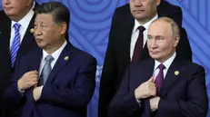 epa11679295 Russian President Vladimir Putin (R) speaks with Chinese President Xi Jinping (2-L) as other participants in the outreach/BRICS Plus format meeting pose for a family photo during the BRICS summit in Kazan, Russia, 24 October 2024. The BRICS summit takes place from 22 to 24 October. EPA/MAXIM SHIPENKOV