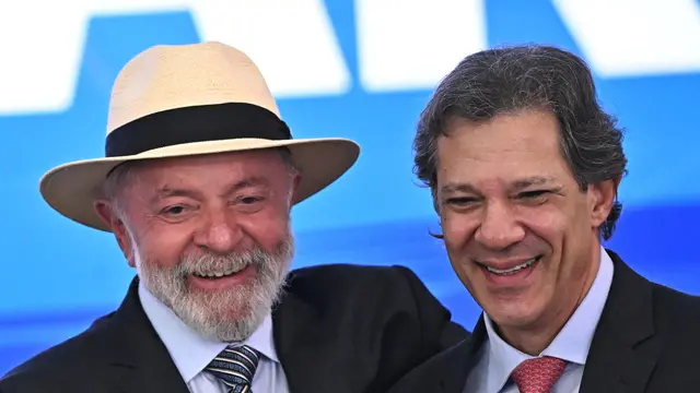 epa11829339 Brazilian President Luiz Iacio Lula da Silva (L) poses with Finance Minister Fernando Haddad during a ceremony at the Planalto Palace in Brasilia, Brazil, 16 January 2025. Lula da Silva sanctioned the regulation of wide-ranging tax reform, which will gradually simplify the current tax system and has enjoyed broad support across the political spectrum. EPA/ANDRE BORGES