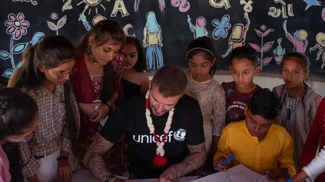 On 14 November 2023 in India, UNICEF Goodwill Ambassador David Beckham (centre) signs a drawing he has made while speaking with a group of adolescents at the community centre in the Banaskantha district of Gujarat state, a reflection of how his time with them has made him feel: ‘Happy’. Mr. Beckham has come to meet with adolescents who are champions of child rights and to hear their personal stories of empowerment – how they have stood up to reject child labour and child marriage and have fought to prevent gender-based violence – as well as descriptions of the support they have received from the community in various ways, including through mental health and psychosocial support (MHPSS). Mr. Beckham travelled to India this week to meet children and adolescents, including girls who are bringing about change and innovation in their communities, and young women who have overcome barriers to help close gender gaps. During his four-day visit, Beckham saw first-hand how UNICEF-supported programmes are making a difference for girls and women, in partnership with the Government of India. The aim of the visit to the community centre was to give a deeper understanding of the context and effective initiatives by community, government and civil society organizations to ensure that every child is protected and empowered (with a gender and equity focus). Adolescents shared their dreams, aspirations, journey so far and the obstacles they have overcome along the way. Community members, front line workers and government functionaries added their experiences, perspectives and insights on the changing times and how the community supports adolescents on their path to greater empowerment, as well as challenges they have faced and how they have overcome them.