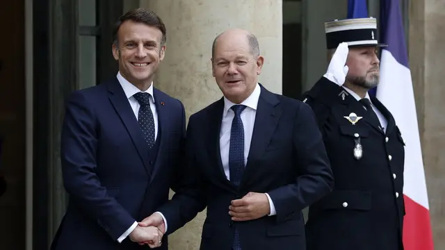 epa11844505 French President Emmanuel Macron (L) greets German Chancellor Olaf Scholz (C) upon the latter's arrival at the Elysee Palace in Paris, France, 22 January 2025. EPA/MOHAMMED BADRA