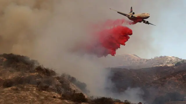 epa11819141 A plane drops fire retardant against the Palisades wildfire in Los Angeles, California, USA, 11 January 2025. Thousands of firefighting and emergency personnel are involved in response efforts, as multiple wildfires are continuing to burn across thousands of acres in Southern California, destroying thousands of homes and forcing people to evacuate areas throughout the Los Angeles area. EPA/ALLISON DINNER